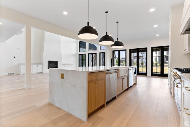 231 S Wiltshire Ln, Saratoga Springs, UT 84045 - kitchen featuring appliances with stainless steel finishes, light wood-style flooring, a large fireplace, recessed lighting, and a large island