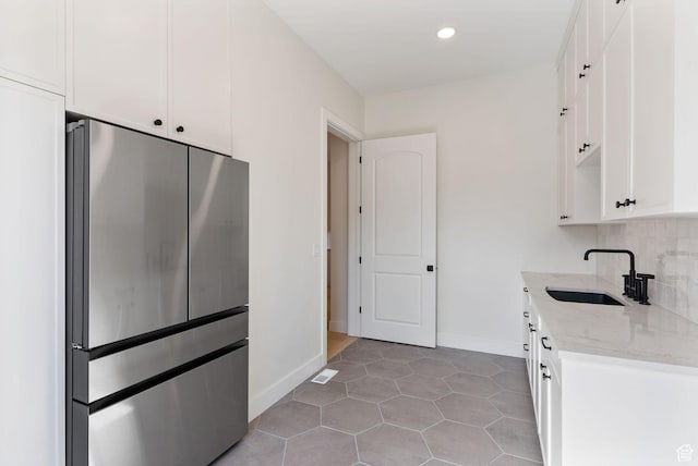 231 S Wiltshire Ln, Saratoga Springs, UT 84045 - kitchen with freestanding refrigerator, a sink, light stone counters, white cabinetry, and recessed lighting