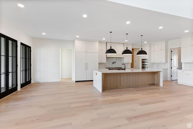 231 S Wiltshire Ln, Saratoga Springs, UT 84045 - kitchen featuring decorative backsplash, light wood finished floors, recessed lighting, a large island, and light countertops