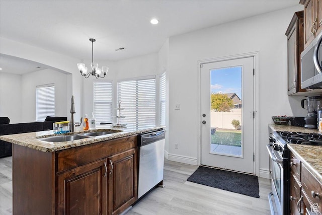 787 E 1950 S, Lehi, UT 84043 - kitchen with stainless steel appliances, a sink, a kitchen island with sink, dark brown cabinets, and light wood-type flooring