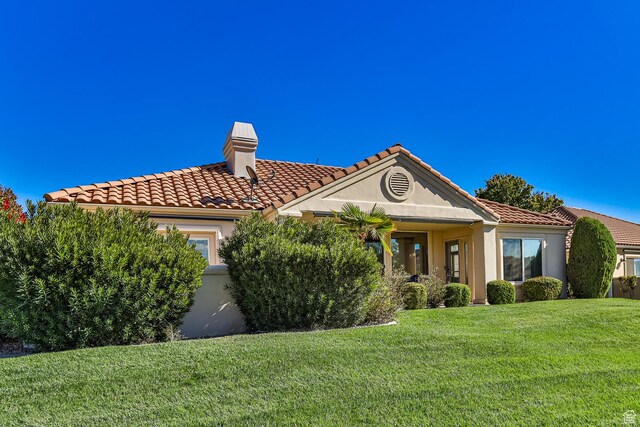 356 N Cactus Ln Unit 9, Washington, UT 84780 - view of front of home with a chimney, a front yard, stucco siding, a tiled roof, and an attached garage