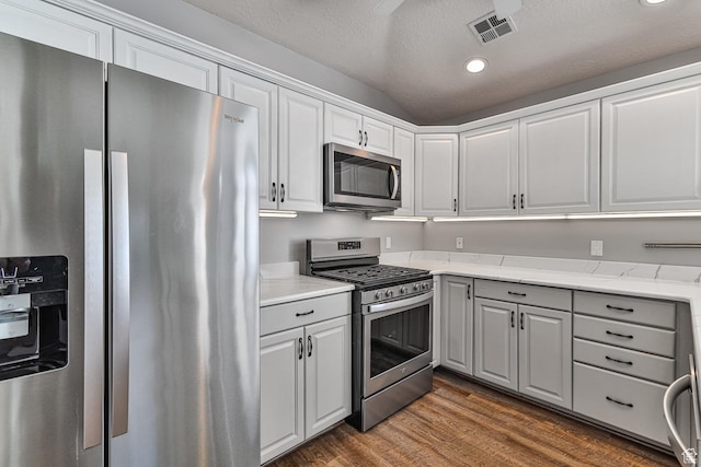 356 N Cactus Ln Unit 9, Washington, UT 84780 - kitchen with stainless steel appliances, dark wood-style flooring, white cabinetry, a textured ceiling, and light stone countertops
