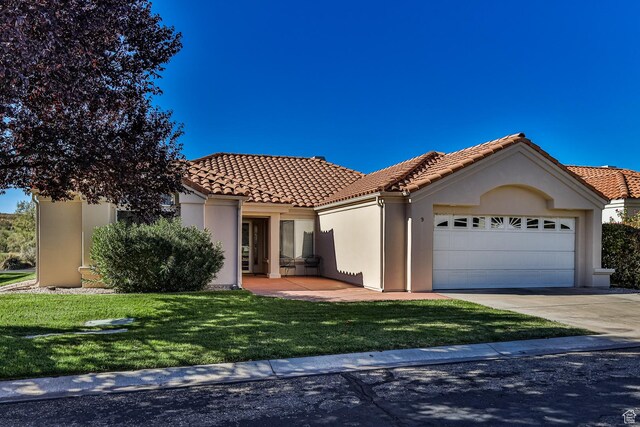 356 N Cactus Ln Unit 9, Washington, UT 84780 - mediterranean / spanish-style house featuring a garage, a front lawn, a tiled roof, concrete driveway, and stucco siding