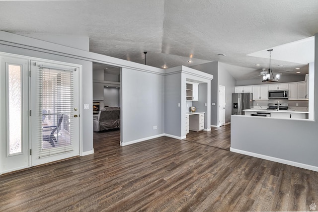 356 N Cactus Ln Unit 9, Washington, UT 84780 - unfurnished living room with vaulted ceiling, a textured ceiling, dark wood finished floors, baseboards, and a chandelier