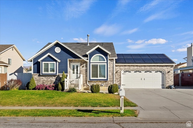 ranch-style house featuring a garage, solar panels, and a front yard