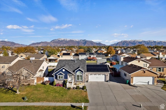view of front of home with a garage, a front lawn, and a mountain view