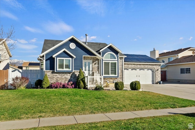 view of front of home with a garage, solar panels, and a front yard