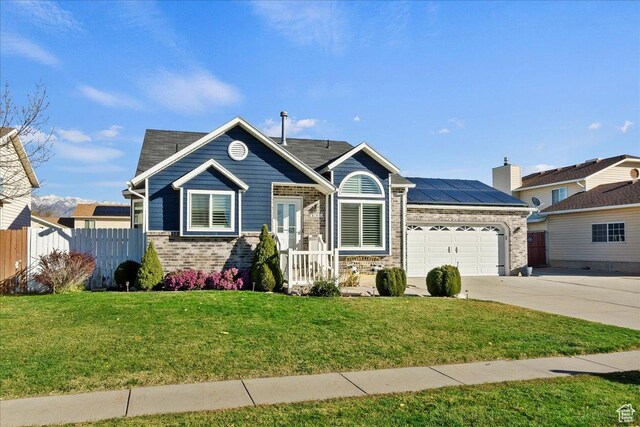 4958 S 3900 W, Roy, UT 84067 - view of front facade with driveway, brick siding, a garage, and roof mounted solar panels