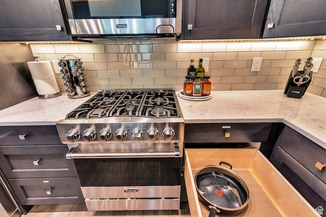10005 N Meer Cir, Heber City, UT 84032 - kitchen featuring light stone countertops, dark brown cabinets, backsplash, and appliances with stainless steel finishes