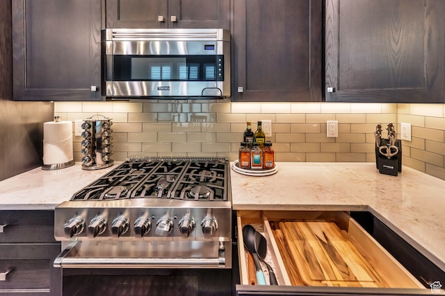 10005 N Meer Cir, Heber City, UT 84032 - kitchen featuring backsplash, dark brown cabinetry, light stone countertops, and stainless steel appliances