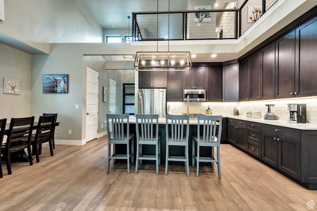 10005 N Meer Cir, Heber City, UT 84032 - kitchen featuring a high ceiling, light hardwood / wood-style flooring, appliances with stainless steel finishes, and hanging light fixtures