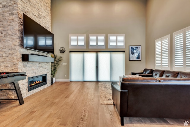 10005 N Meer Cir, Heber City, UT 84032 - living room featuring a stone fireplace, light hardwood / wood-style floors, and a towering ceiling