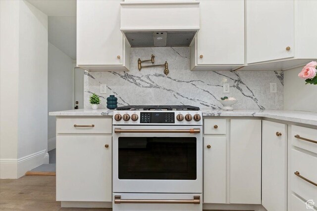 855 S 700 E, Salt Lake City, UT 84102 - kitchen featuring gas range oven, custom exhaust hood, white cabinets, backsplash, and wood finished floors