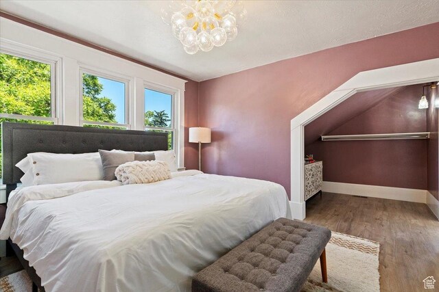 855 S 700 E, Salt Lake City, UT 84102 - bedroom with multiple windows, a chandelier, baseboards, and wood finished floors