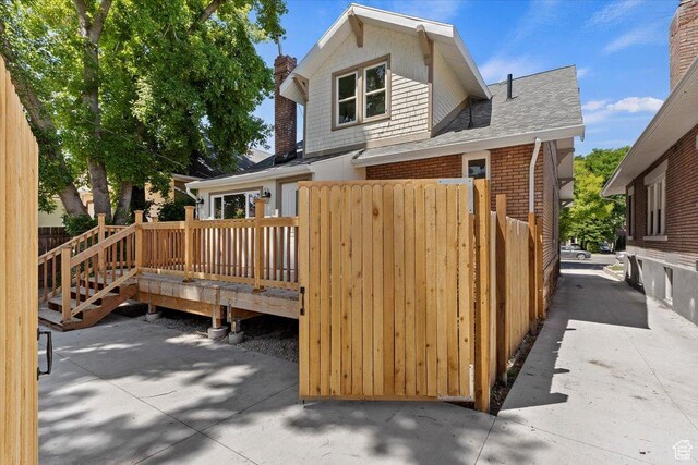 855 S 700 E, Salt Lake City, UT 84102 - back of property featuring a deck, fence, brick siding, a shingled roof, and a chimney