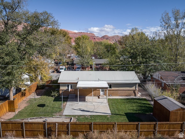 321 Park Rd, Moab, UT 84532 - back of house featuring a fenced backyard, a metal roof, a mountain view, and a patio
