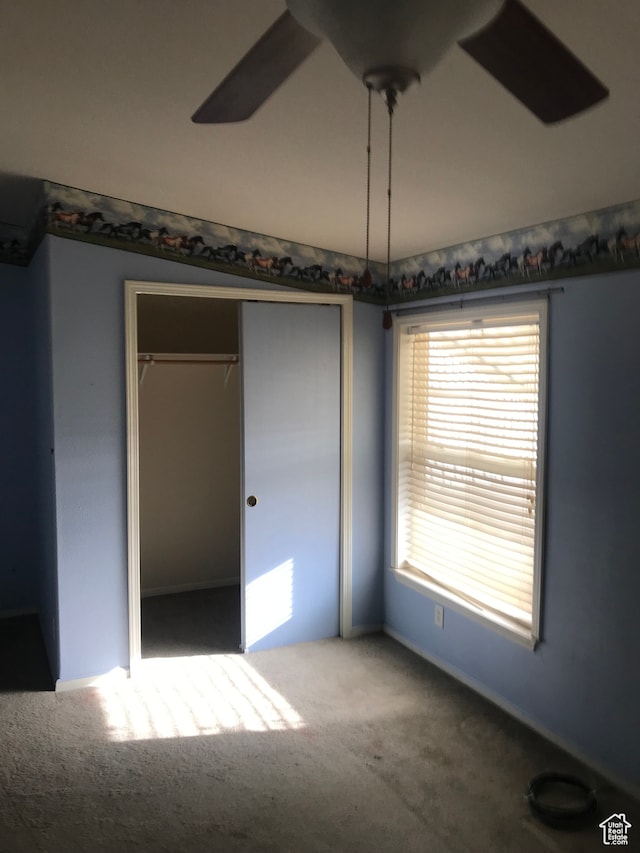 unfurnished bedroom with a closet, ceiling fan, and carpet floors