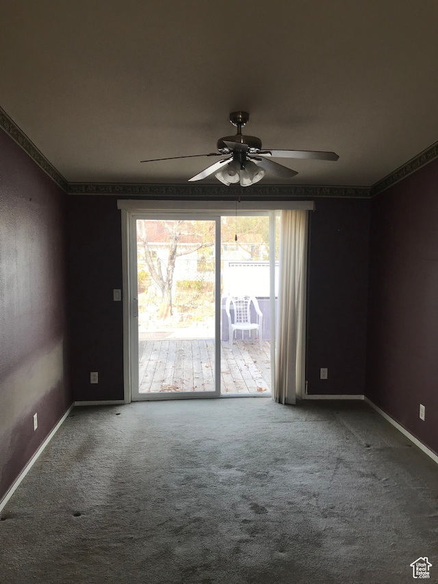 carpeted spare room featuring ceiling fan
