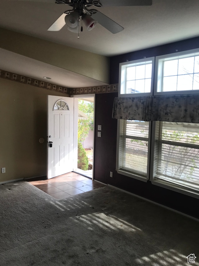 carpeted entryway featuring ceiling fan