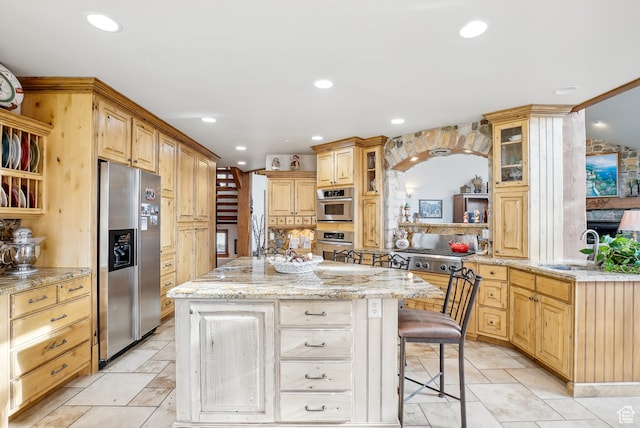 kitchen with a breakfast bar, stainless steel fridge, light stone countertops, a kitchen island, and kitchen peninsula