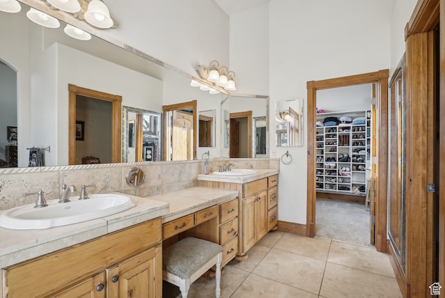 bathroom featuring tile patterned flooring, vanity, and a high ceiling