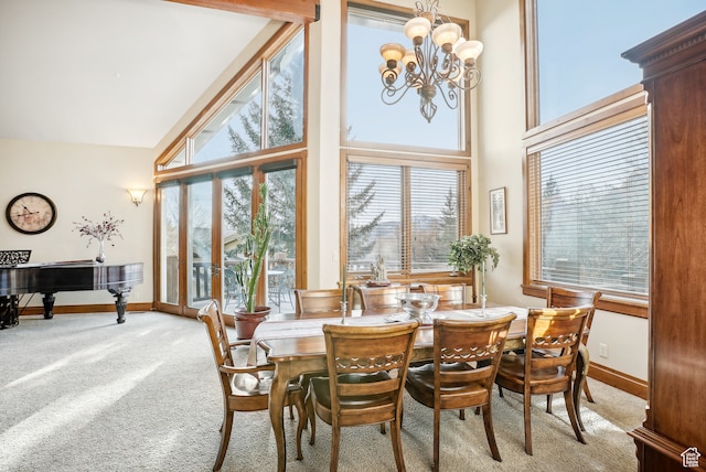carpeted dining area featuring a chandelier, high vaulted ceiling, and a healthy amount of sunlight