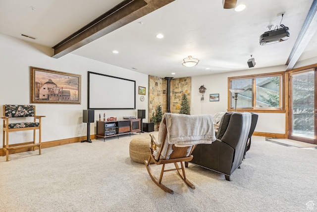 home theater room with beamed ceiling and light colored carpet