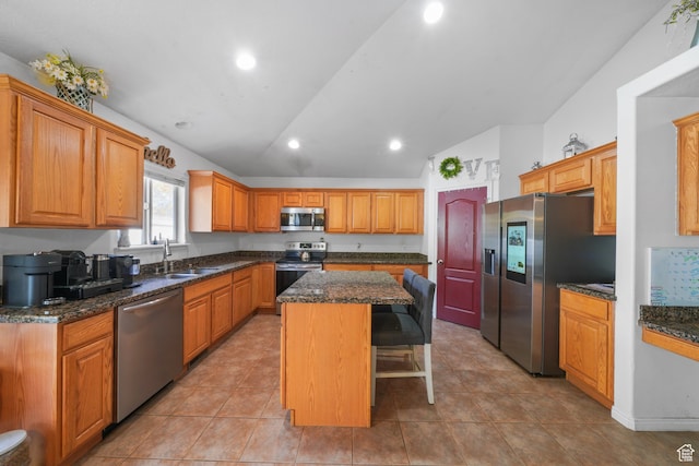 1567 S 1700 E, Spanish Fork, UT 84660 - kitchen with light tile patterned flooring, appliances with stainless steel finishes, a kitchen bar, vaulted ceiling, and a center island