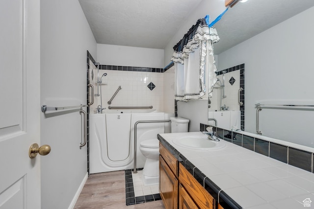 3635 S Arbor Park Dr, Magna, UT 84044 - bathroom featuring toilet, wood finished floors, vanity, and a textured ceiling