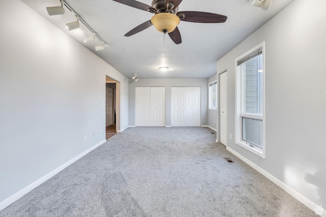 3635 S Arbor Park Dr, Magna, UT 84044 - unfurnished bedroom featuring multiple closets, carpet floors, baseboards, and track lighting