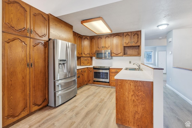 3635 S Arbor Park Dr, Magna, UT 84044 - kitchen featuring appliances with stainless steel finishes, a sink, brown cabinets, and light wood-style flooring