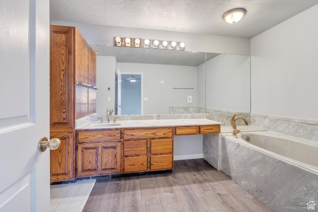 3635 S Arbor Park Dr, Magna, UT 84044 - full bath featuring vanity, wood finished floors, a bath, and a textured ceiling