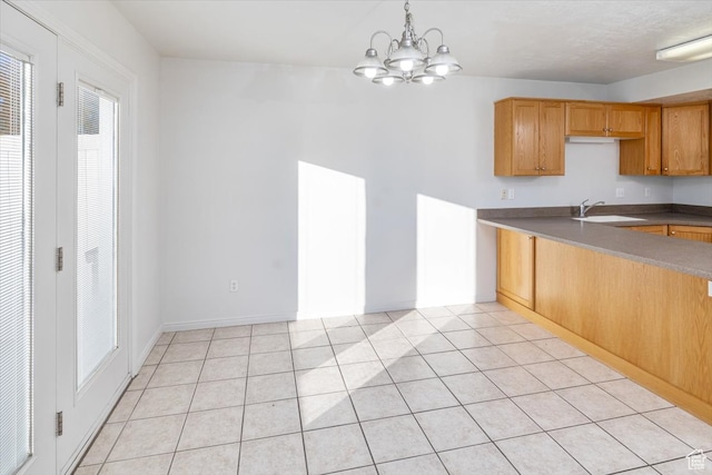 kitchen featuring hanging light fixtures, sink, a chandelier, and light tile patterned floors