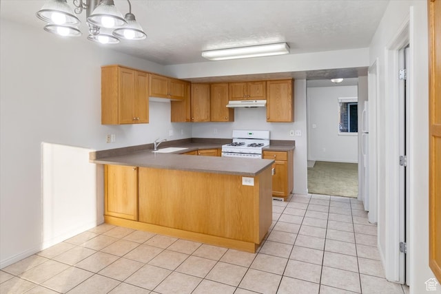 kitchen featuring sink, kitchen peninsula, light tile patterned floors, white range with gas stovetop, and hanging light fixtures