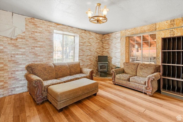 165 S 200 W, Manti, UT 84642 - living area featuring a chandelier, hardwood / wood-style floors, a wood stove, a textured ceiling, and brick wall