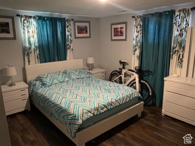 bedroom featuring dark wood-type flooring and a textured ceiling