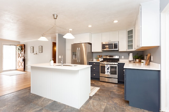 kitchen featuring white cabinetry, stainless steel appliances, sink, and decorative light fixtures