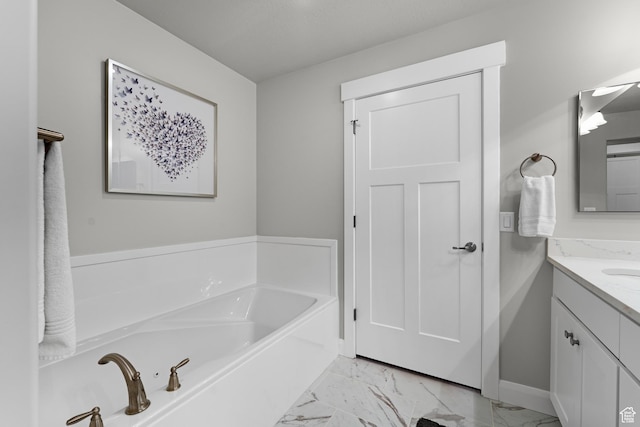 519 N Pintail Ln Unit C, Vineyard, UT 84059 - bathroom featuring vanity, a garden tub, marble look tile flooring, and baseboards