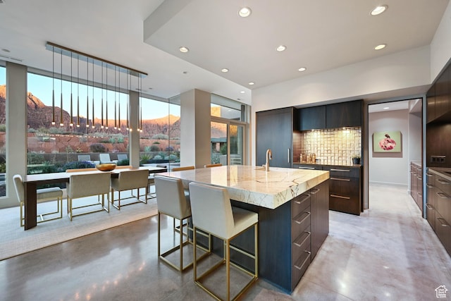 1748 N Cochise Dr, Ivins, UT 84738 - kitchen with modern cabinets, finished concrete flooring, a large island with sink, recessed lighting, and floor to ceiling windows