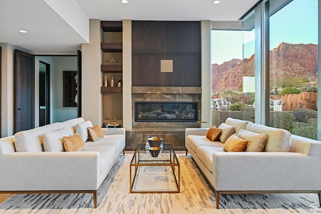 1748 N Cochise Dr, Ivins, UT 84738 - living area featuring a mountain view, wood finished floors, recessed lighting, a glass covered fireplace, and built in shelves