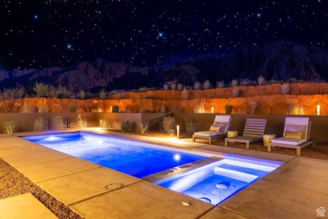 1748 N Cochise Dr, Ivins, UT 84738 - pool at twilight featuring an in-ground hot tub, a fenced backyard, and a patio