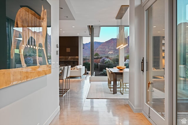 1748 N Cochise Dr, Ivins, UT 84738 - hallway with finished concrete flooring, floor to ceiling windows, a mountain view, and baseboards