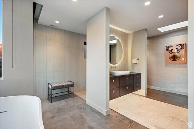 1748 N Cochise Dr, Ivins, UT 84738 - bathroom featuring a freestanding tub, vanity, a skylight, recessed lighting, and concrete flooring