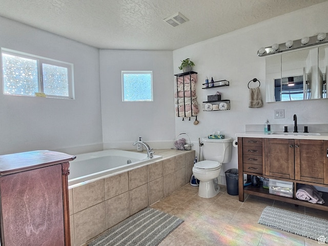 660 S 2500 W, Vernal, UT 84078 - bathroom with tile patterned floors, vanity, a textured ceiling, a relaxing tiled tub, and toilet