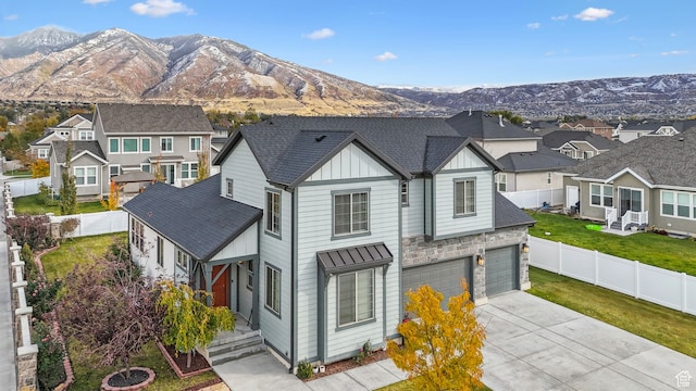 view of front of property featuring a mountain view, a garage, and a front lawn