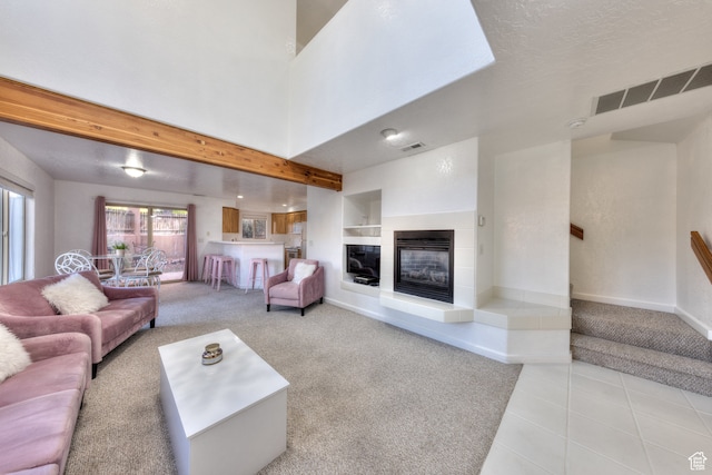 385 E Pueblo Ct, Moab, UT 84532 - tiled living room featuring beamed ceiling, a tiled fireplace, and a textured ceiling