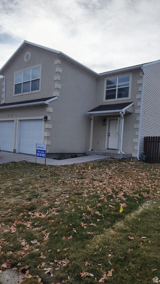 front of property featuring a front lawn and a garage