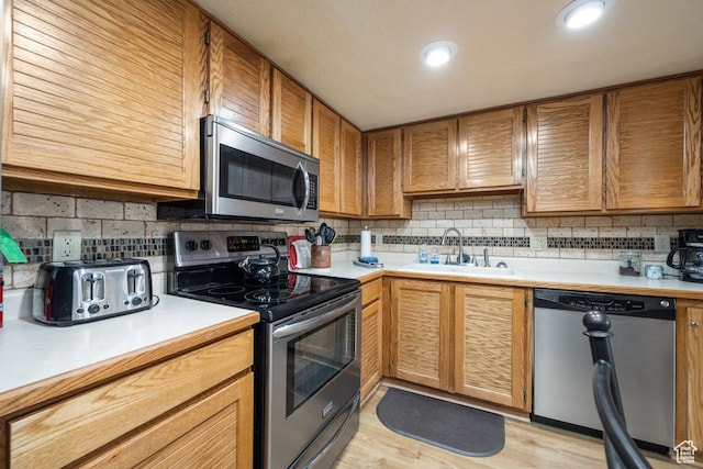 150 W Ridgeview St Unit 220, Brian Head, UT 84719 - kitchen featuring decorative backsplash, appliances with stainless steel finishes, sink, and light hardwood / wood-style flooring