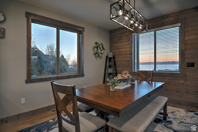 1400 N Cisco Cir, Garden City, UT 84028 - dining area featuring wooden walls, a chandelier, wood finished floors, and baseboards
