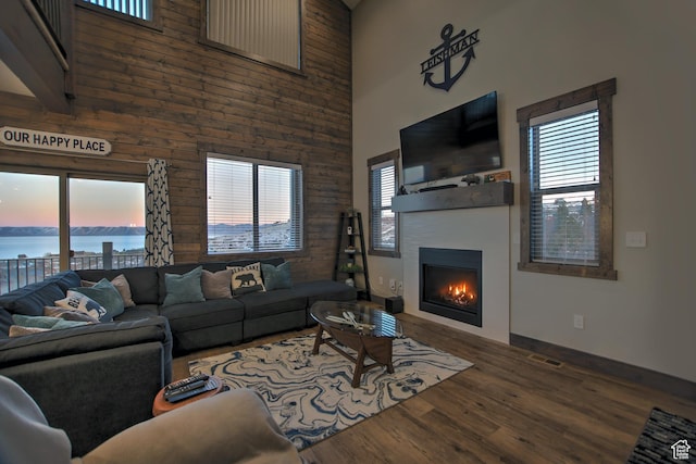 1400 N Cisco Cir, Garden City, UT 84028 - living room featuring a towering ceiling, a water view, a glass covered fireplace, wood finished floors, and baseboards
